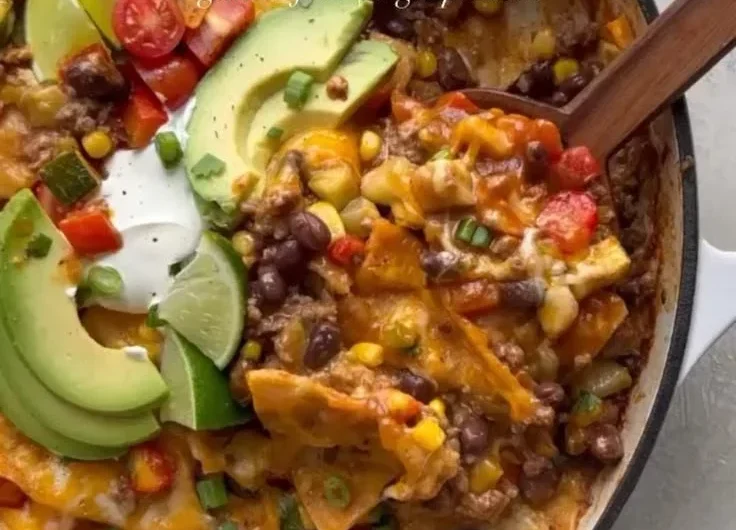 Delicious one pan enchilada skillet with vibrant toppings and melted cheese.