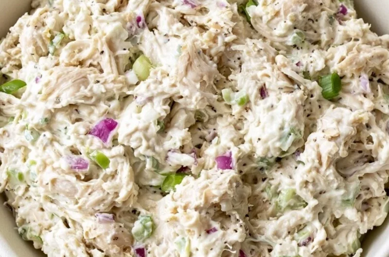 Delicious chicken salad garnished with fresh vegetables and herbs