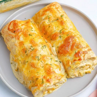 Delicious creamy white chicken enchiladas topped with cheese and herbs
