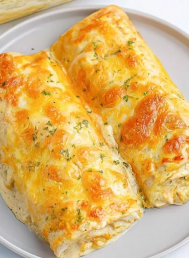 Delicious creamy white chicken enchiladas topped with cheese and herbs