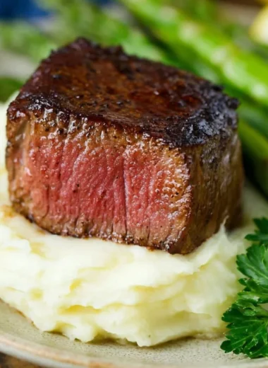 Delicious Garlic Herb Butter Filet Mignon served on a plate with herbs