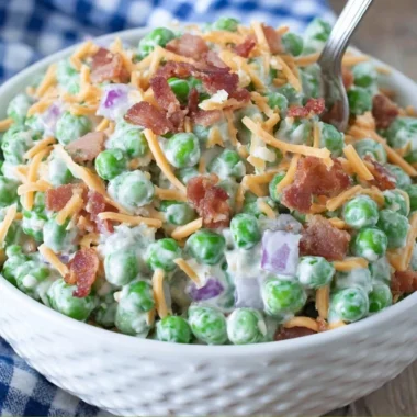 Bowl of old fashioned pea salad with bacon, onions, and creamy dressing