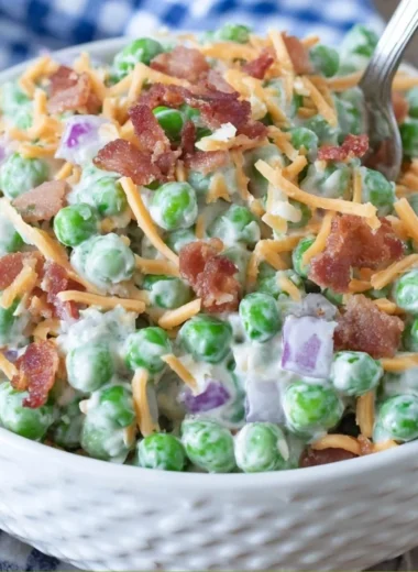 Bowl of old fashioned pea salad with bacon, onions, and creamy dressing