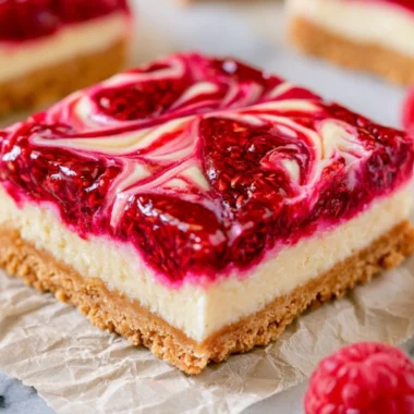 Delicious Raspberry Cheesecake Bars topped with fresh raspberries