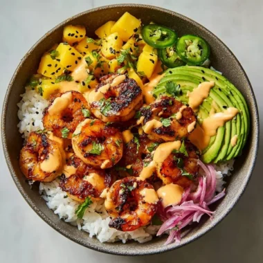 A vibrant charred shrimp and avocado bowl garnished with fresh herbs.