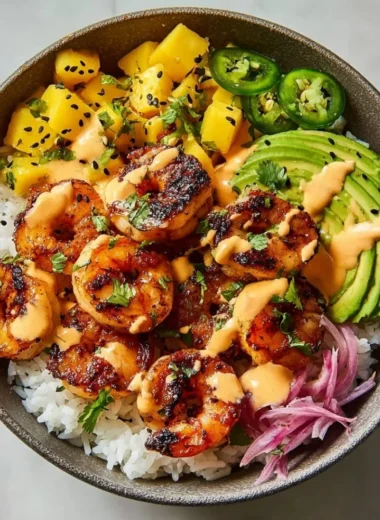 A vibrant charred shrimp and avocado bowl garnished with fresh herbs.
