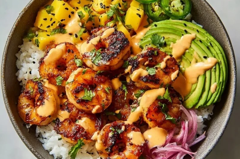 A vibrant charred shrimp and avocado bowl garnished with fresh herbs.