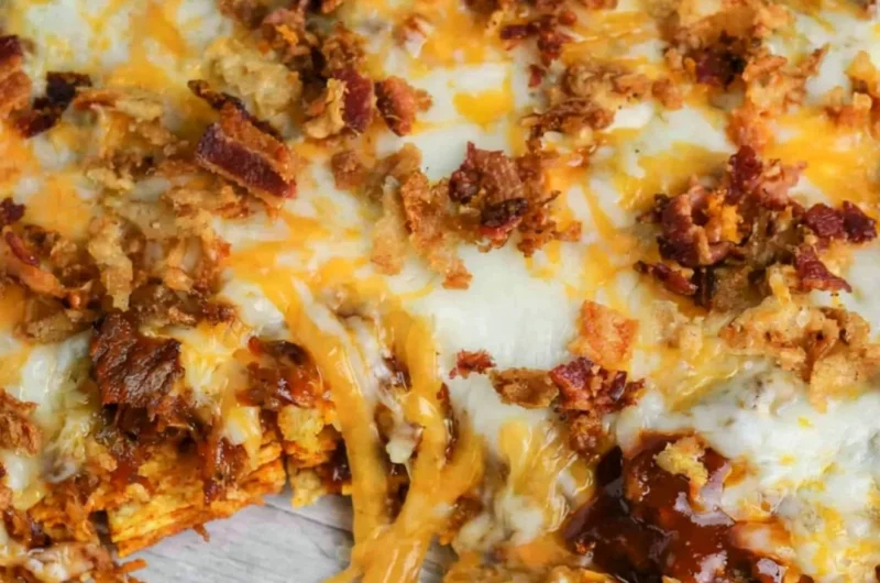 BBQ Bacon Cheeseburger Frito Pie topped with cheese and crispy bacon