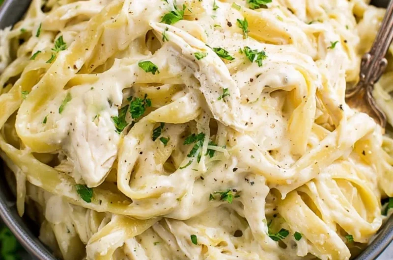 Creamy Instant Pot Chicken Alfredo served with pasta on a wooden table