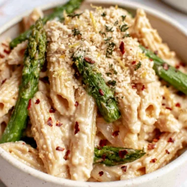 Creamy lemon white bean pasta served in a bowl garnished with fresh herbs.