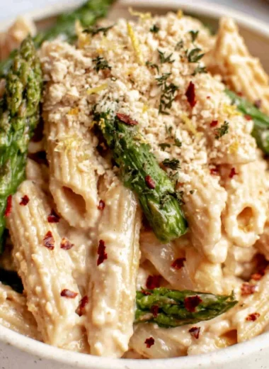 Creamy lemon white bean pasta served in a bowl garnished with fresh herbs.