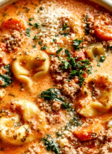 Bowl of Crockpot tortellini soup with vegetables and herbs