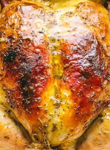 Juicy Dutch Oven whole chicken served with herbs and vegetables.