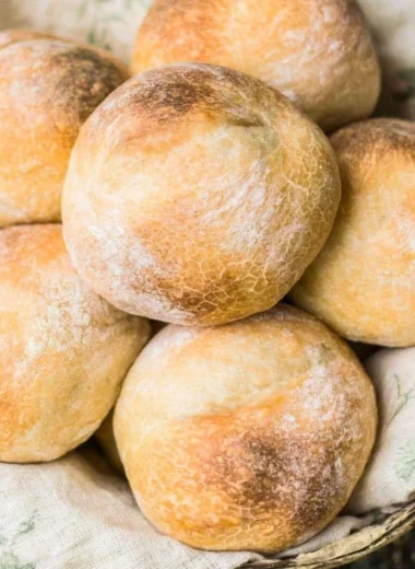 Freshly baked sourdough rolls on a wooden table