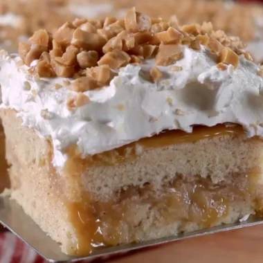 Delicious caramel apple poke cake topped with creamy caramel sauce and apple slices
