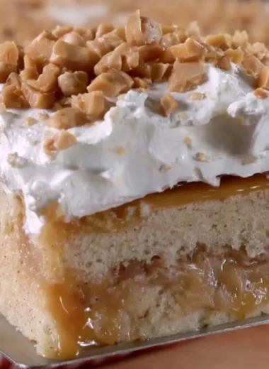 Delicious caramel apple poke cake topped with creamy caramel sauce and apple slices